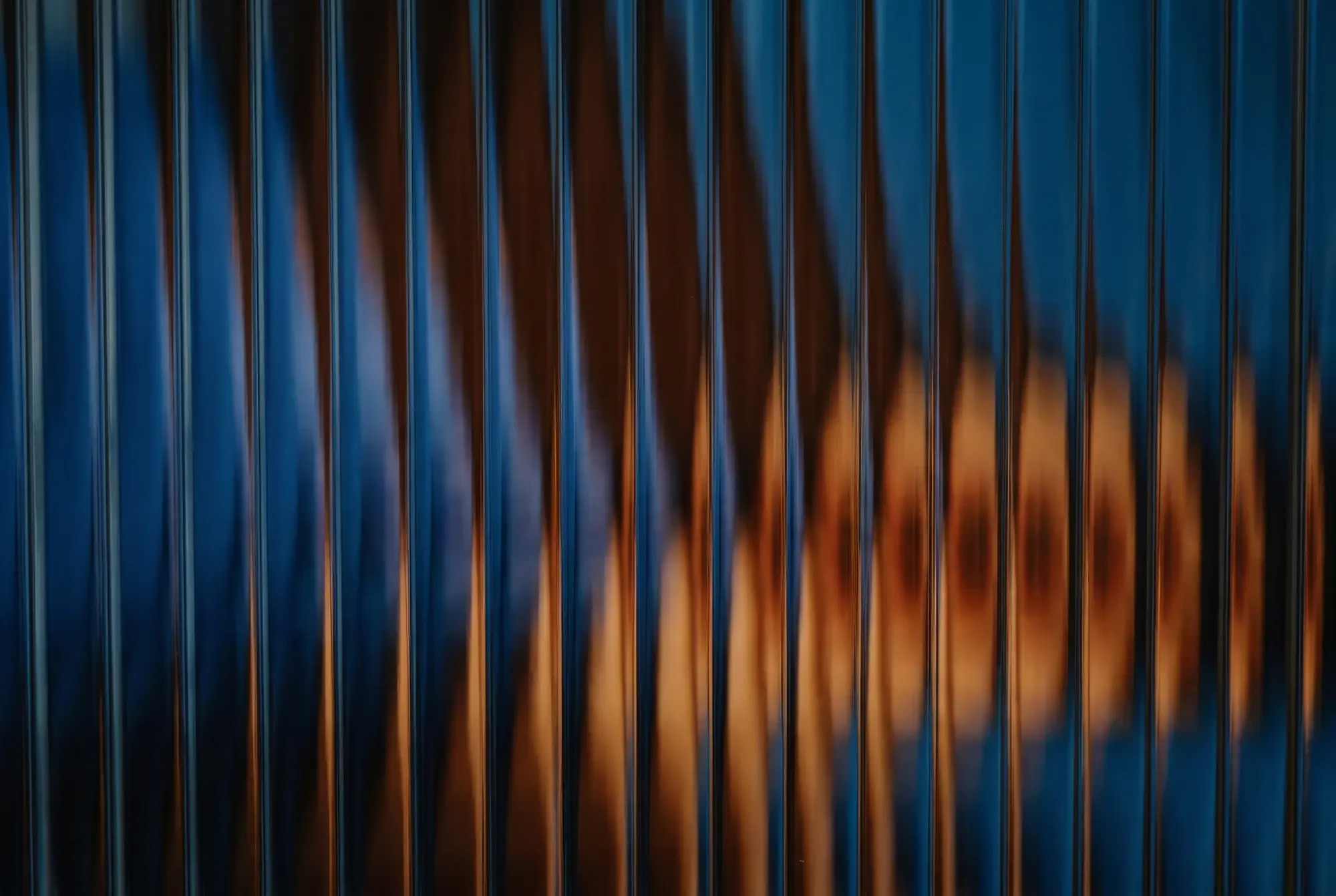 Abstract forms and colors of blue and orange shades behind glass